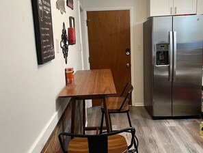 Enjoy meals at the kitchen table with a stainless steel refrigerator nearby.