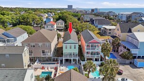 A residential area with houses, a swimming pool, and a view of the ocean.