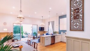 A spacious kitchen with a central island, pendant lighting, and a decorative screen on the wall. - 4 BR Luxury Designer Home Hot Tub, Parking Garage Near San Francisco UC Berkeley (Oakland)