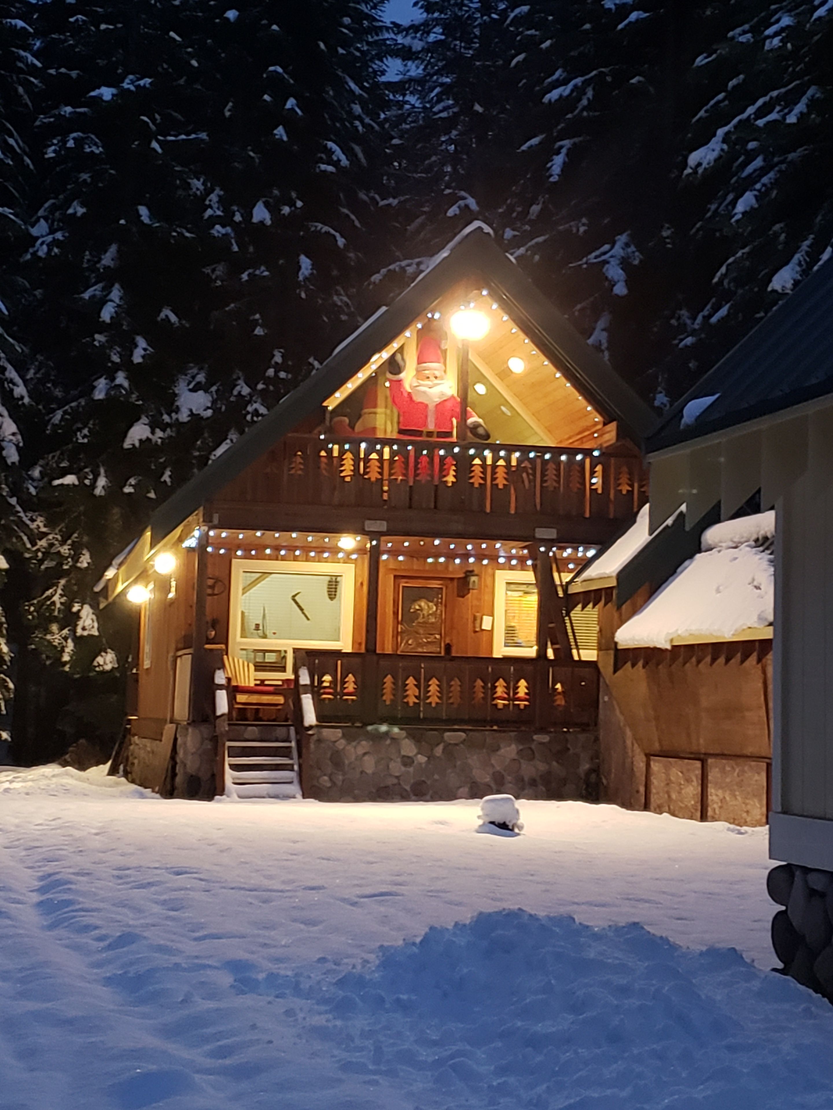 Une cabane en bois dotée d’un balcon, d’un escalier menant à l’entrée et de la neige au sol.