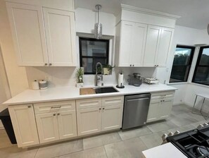 Enjoy cooking in this well-lit kitchen with an oven and stainless steel dishwasher.