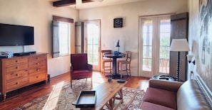 Relax in this open-plan living area with a flat-screen TV, comfortable seating, and a convenient dresser.