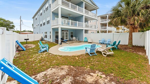 A multi-story building with a pool, outdoor seating, and a slide. - 5BR | Sleeps 17 | Pool | Close To The Beach | 7092 (North Myrtle Beach)