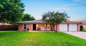 A single-story house with a front porch, a garage, and a well-maintained lawn. - Villa D’Oro, Minutes to AT&T Stadium, Pool, Spa,Arcade, Game Room (North Richland Hills)