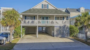 A two-story house with a covered driveway and a garage. - 6BR | Sleeps 16 | Pool | Steps To The Beach |20427 (North Myrtle Beach)