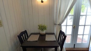 A dining table with two chairs, a potted plant, and a placemat. - Romantic Tiny Cabin- With Lake View (Lake Arrowhead)