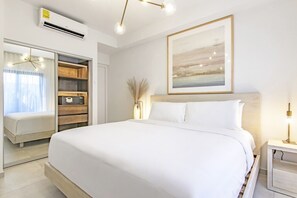 Un dormitorio moderno con una cama grande, un armario, una mesita de noche y un ventilador de techo.