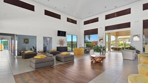 A spacious lobby with a mix of seating areas, including sofas and a coffee table, and a view of the outdoors.