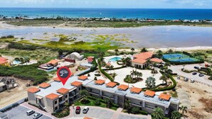 An aerial view of a resort with multiple buildings, a swimming pool, and a beach area.