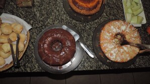 Ett buffébord med olika sorters desserter, inklusive en chokladtårta, en sockerkakstårta och en tårta med vit glasyr.