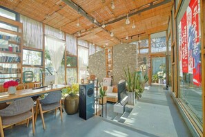 A modern interior with a wooden ceiling, large windows, and a stone accent wall. - Dali Village Inn (Dali City)