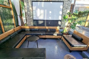 Un espace extérieur moderne, aménagé avec un mur en pierre, une grande fenêtre et un pot de fleurs.