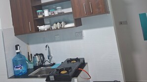 A kitchen with a gas stove, a microwave, and wooden cabinets.