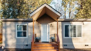 A single-story mobile home with a front porch, a door, and two windows. - Neptune Haven Getaway Near the Ocean  (Ferndale)