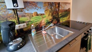 A kitchen with a stainless steel sink, a coffee maker, and a kettle. - Sch(l)afgemach Schäferwagen - Farm in the Eifel (Nettersheim)