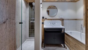 A modern bathroom with a shower, a sink, a mirror, and a bathtub. - Charming apartment for 8 with parking and WIFI near the slopes (Montvalezan-La Rosière)