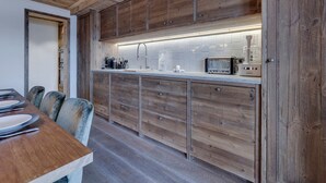 A kitchen with wooden cabinets, a countertop, and a toaster. - Charming apartment for 8 with parking and WIFI near the slopes (Montvalezan-La Rosière)