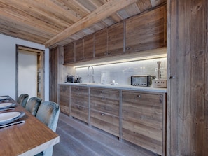 A kitchen with wooden cabinets, a countertop, and a toaster.