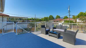 Ein Balkon mit Gartenmöbeln und Blick auf die Umgebung.