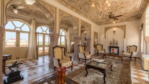 A spacious room with ornate ceiling and arches, large windows, and traditional furniture. - Mundota Fort and Palace (Jalsu)