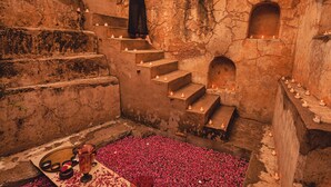 A person standing on stone steps with candles and flower petals on the floor. - Mundota Fort and Palace (Jalsu)