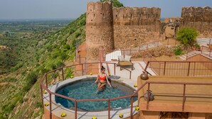 A swimming pool with a view of a historic castle and surrounding landscape. - Mundota Fort and Palace (Jalsu)