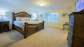 A bedroom with a large bed, a dresser, a nightstand, and a window with blinds. - Tacoma House INN W/ Centralized AC (Tacoma)