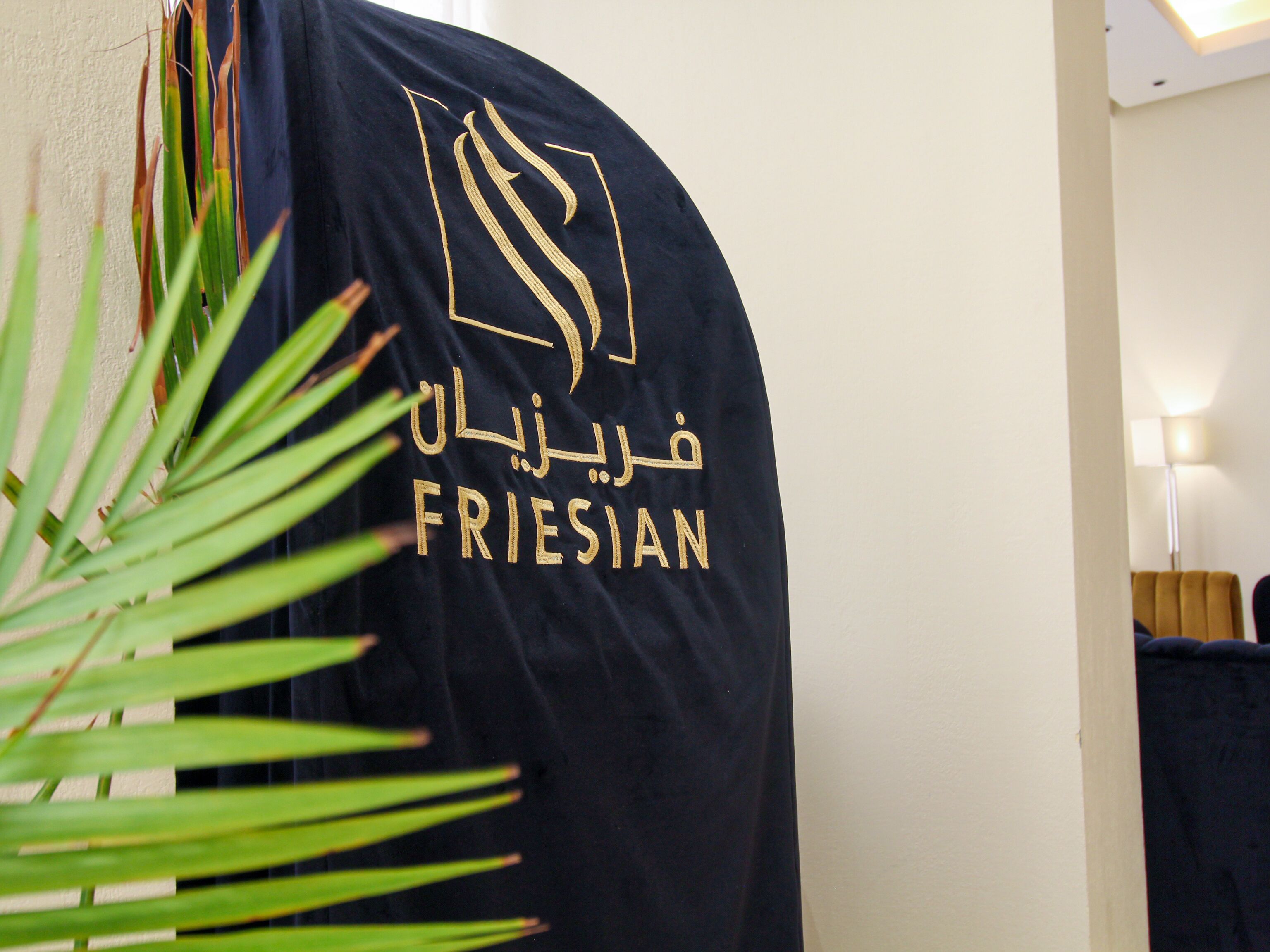 A room with a dark-colored wall and a black curtain with gold embroidery.