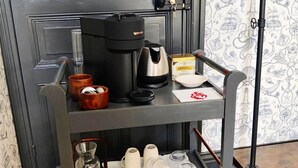 Un coin cuisine équipé d’une machine à café, d’une boîte de thé Earl Grey de la marque Twinings, et d’un plateau avec des tasses et une théière.