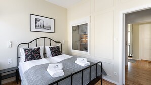 A neatly made bed with a grey quilt, two pillows, and a framed picture on the wall. - London - Cozy City Stay by Lion Apartments Sopot (Sopot)