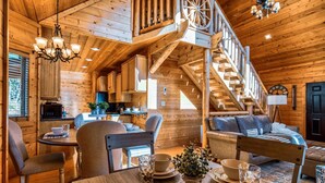 Ein gemütliches Blockhaus-Interieur mit Essbereich, einer Treppe und einem Wohnzimmer.