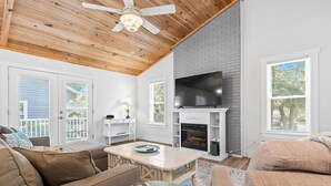 Una sala de estar acogedora con chimenea, televisor y ventilador de techo.