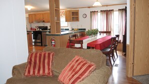 A cozy living room with a sofa and a dining area with a table and chairs. - At Home Base IV, 1 of 4 units. You'll feel right at home,1/2 mile to Dreams Park (Milford)