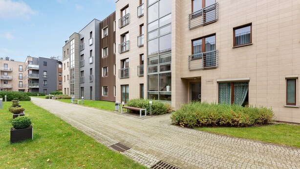 A modern apartment building with a paved walkway, green lawns, and a well-maintained garden area. - Lion Apartments - Parkur 2 (Sopot)
