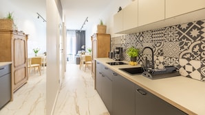 Une cuisine moderne avec un sol en marbre, un pare-feu décoré et des armoires en bois.
