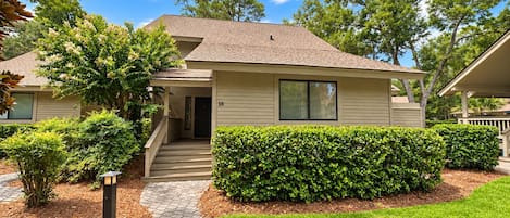 A two-story house with a front porch, a mailbox, and a well-maintained lawn.