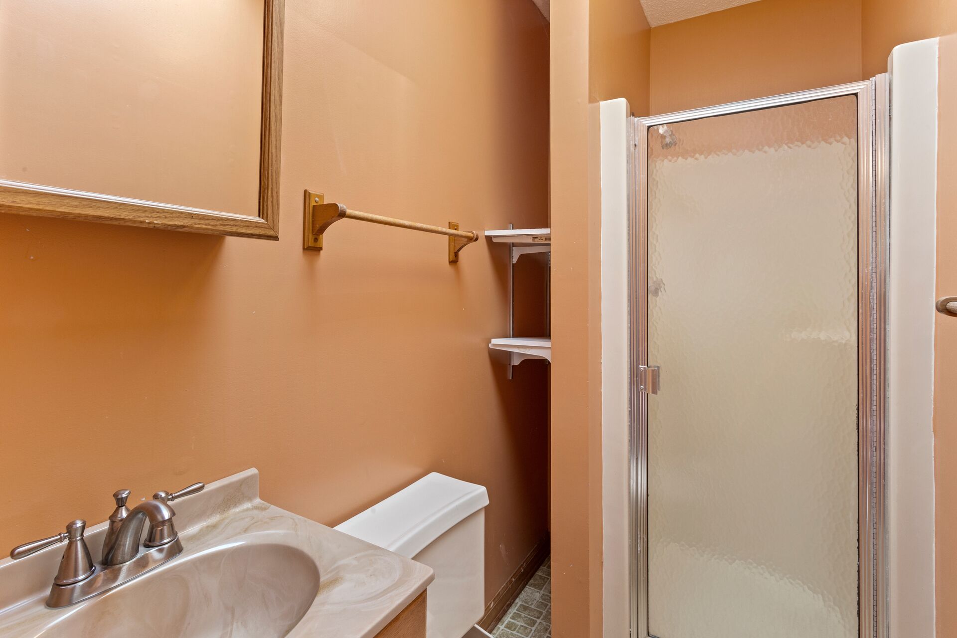 A bathroom with a sink, toilet, and a walk-in shower.
