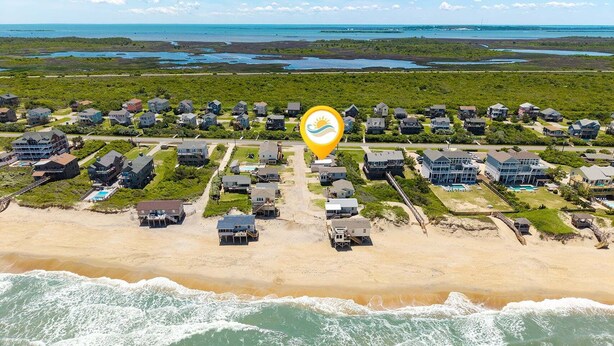 An aerial view of a coastal residential area with houses, a beach, and a body of water. - Beach, Sunrise, Views, community pool! (Nags Head)