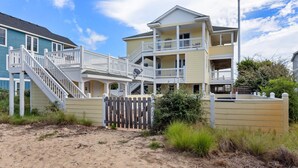 A multi-story beachfront property with a balcony and a staircase leading to the upper levels. - Overdraft: Steps to Beach, Pool, Hot Tub, 7BR OBX (Southern Shores)