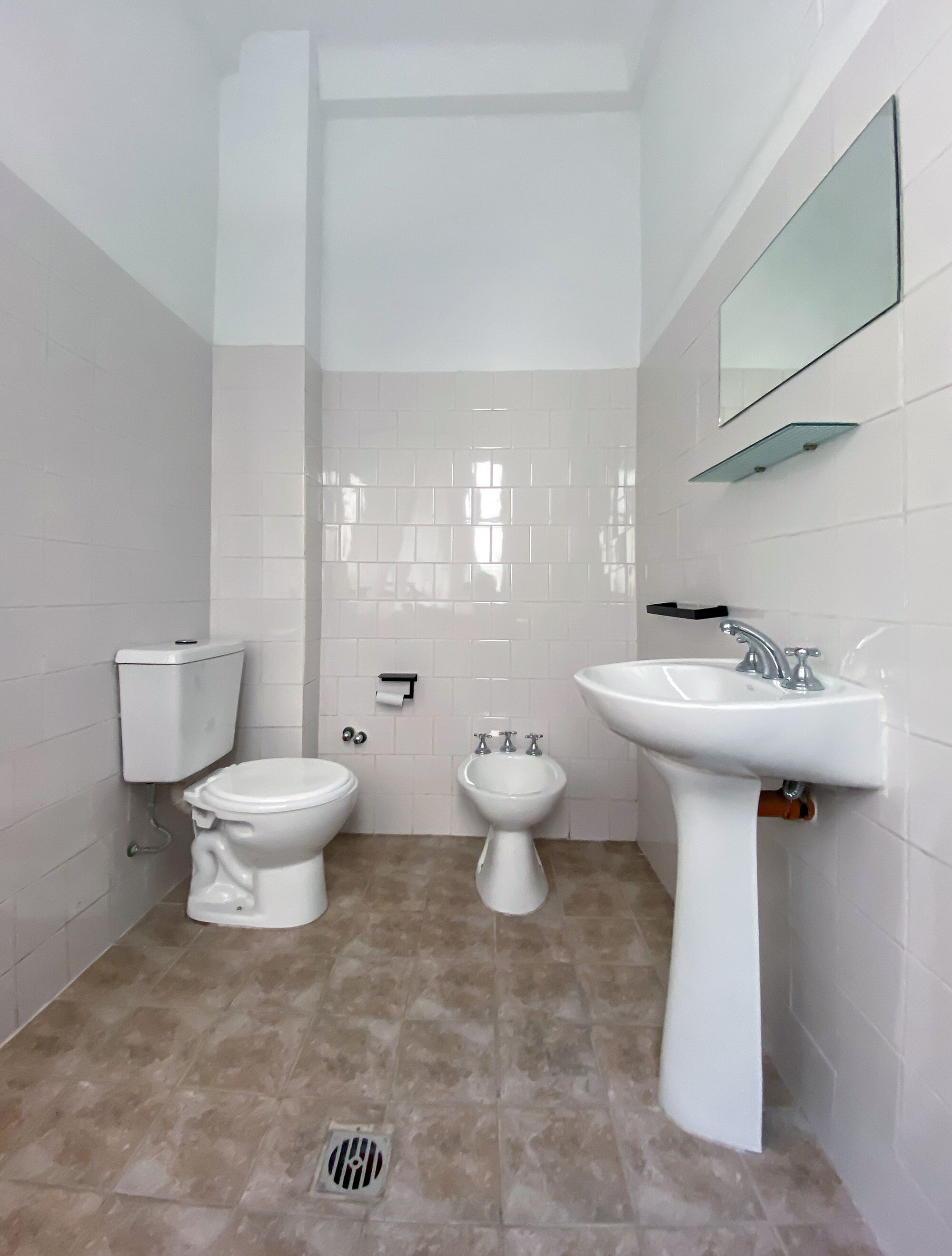 A bathroom with a toilet, bidet, and sink.