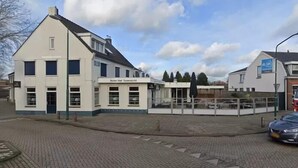 Een gebouw met twee verdiepingen, met een bord waarop staat 'Hotel Het Torensicht'.