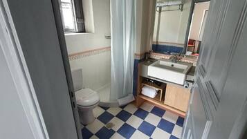 A bathroom with a toilet, sink, and mirror.
