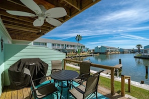 Relax on the serene outdoor deck with a dining or relaxation area overlooking the calm body of water.
