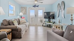 A living room with a sofa, a coffee table, a TV, and decorative items.