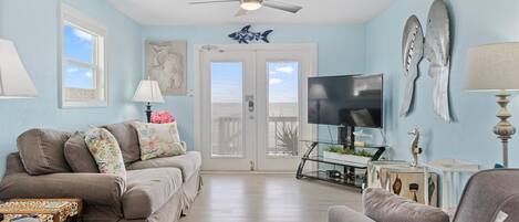 A living room with a sofa, a coffee table, a TV, and decorative items.