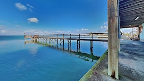 A pier extending into calm waters with a clear sky. - Pelican Point by Miss Kitty’s (Rockport)