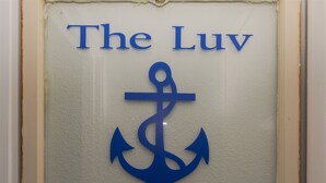 A framed sign with a blue anchor symbol and the text "The Luv est. 1977". - Fisherman Luv by Miss Kitty’s (Rockport)