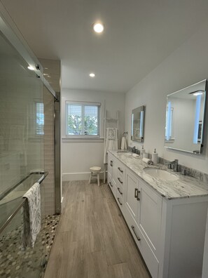 A modern bathroom with a glass shower enclosure, a vanity with a sink, and a large mirror. - Modern Beach LakeFront House in Miami ! (Miami)