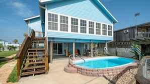 A two-story house with a swimming pool, a wooden staircase, and a covered patio area. - Hook, Wine & Sinker by Miss Kitty’s (Rockport)