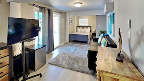 A compact room with a bed, a TV, a desk, and a radiator. - Hook, Wine & Sinker by Miss Kitty’s (Rockport)